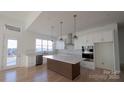 Bright kitchen with island, pendant lighting, white cabinetry, and stainless steel appliances at 4227 Holly Ne Cir, Conover, NC 28613