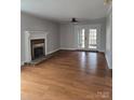 Spacious living room featuring hardwood floors, fireplace, and french doors at 446 Windsor Ln, Statesville, NC 28677