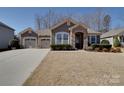 Charming single-story home featuring a stone archway, dual garage, and manicured front lawn at 5017 Willing Ct # 124, Indian Land, SC 29707