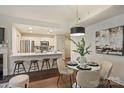Open-concept kitchen and dining area featuring white cabinets, stainless steel appliances, and a breakfast bar at 718 W Trade St # 307, Charlotte, NC 28202