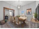 Elegant dining room boasts a rustic table, upholstered chairs, and eye-catching light fixture at 1336 Eisenhower Nw Pl, Concord, NC 28027