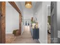 Hallway featuring wood floors, an ornate side board, and stylish hanging light fixture at 1336 Eisenhower Nw Pl, Concord, NC 28027