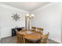 Formal dining area featuring a round wooden table, six chairs, elegant chandelier, and decorative wall accents at 156 Sugar Hill Rd, Troutman, NC 28166