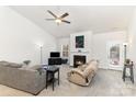 Bright living room with a ceiling fan, fireplace, neutral walls, comfortable couches, and plenty of natural light at 156 Sugar Hill Rd, Troutman, NC 28166