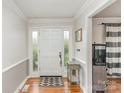 Inviting entryway with hardwood floors, decorative molding, and a front door with glass sidelights at 2156 Flynn Dr, Gastonia, NC 28054