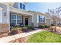 Inviting front porch with stone accents, dark shutters, and a black front door at 2455 Seagull Dr # 62, Denver, NC 28037
