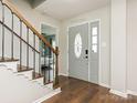 Light-filled foyer with staircase, hardwood floors, and decorative front door provides a welcoming entry to the home at 2602 Cherokee Ct, Gastonia, NC 28056
