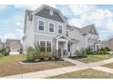 Charming two-story home with light blue siding, landscaped front yard, and inviting entrance at 3017 Woodlands Creek Dr, Monroe, NC 28110