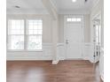 Bright foyer features hardwood floors, white trim, wainscoting, and a view to the entry door at 3017 Woodlands Creek Dr, Monroe, NC 28110