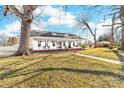 Quaint white house boasts a wrap-around porch and a well-manicured front yard with mature trees at 308 W First St, Lowell, NC 28098