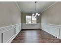 Dining room boasting wood floors, wainscoting, window and modern chandelier at 3420 Donnington Way, Gastonia, NC 28056