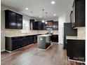 A kitchen showcasing an island, granite countertops, dark wood cabinets and stainless steel appliances at 3420 Donnington Way, Gastonia, NC 28056