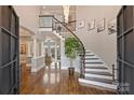 Elegant foyer with a curved staircase, iron railings, hardwood floors, and soaring ceilings at 4335 Piper Glen Dr, Charlotte, NC 28277