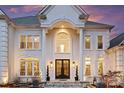 Close-up of the grand entrance with double doors, decorative columns, and elegant lighting at 4335 Piper Glen Dr, Charlotte, NC 28277