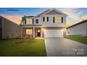 Two-story home boasts brick and siding accents, a well-manicured lawn, and a two-car garage at 469 Court House Ave, York, SC 29745