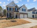 Charming two-story home with brick and white siding, a well-manicured lawn, and a two-car garage at 5056 Blue Serenity Ct, Denver, NC 28037