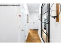 Bright hallway with hardwood floors, stylish mirror, and white doors at 535 Trading Post Ln, York, SC 29745