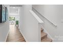 Bright hallway with carpeted stairs, white walls, wooden floors and decorative artwork at 537 Trading Post Ln, York, SC 29745