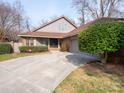 Charming home featuring a long concrete driveway and a well-maintained lawn at 6200 Summertree Ln, Charlotte, NC 28226