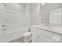 Clean, all-white bathroom with tub, toilet, vanity and modern sink fixtures at 769 River Park Rd, Belmont, NC 28012