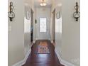 Hallway with hardwood floors, neutral walls, and decorative wall sconces at 112 Jobe Dr, Statesville, NC 28677