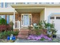 Inviting front porch with brick accents, a variety of foliage and flowers, and seating for guests at 11416 Leadenhall Ln # 22, Charlotte, NC 28262