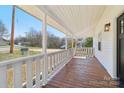 Relaxing front porch with stained wood flooring and white railings offer a cozy outdoor space at 1156 9Th St, Lancaster, SC 29720