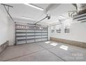 Spacious and well-lit two-car garage featuring a concrete floor, automatic door, and natural light at 3115 Pinehurst Pl, Charlotte, NC 28209