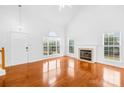Bright living room with large windows, a fireplace, and gleaming hardwood floors at 13705 Queenswater Ln, Charlotte, NC 28273