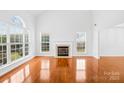 Bright living room with large windows, a fireplace and beautiful hardwood floors at 13705 Queenswater Ln, Charlotte, NC 28273