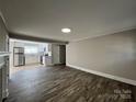 Open-concept living room with hardwood floors, and a seamless flow to kitchen at 1408 Linwood Rd, Gastonia, NC 28052