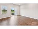 Bright living room with hardwood floors and a sliding glass door leading to the backyard at 1732 Braemar Village Dr, Monroe, NC 28110