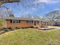 Charming brick ranch home featuring manicured landscaping and a covered carport at 206 Oshea Ave, Gastonia, NC 28056