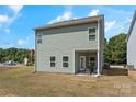 Back exterior view showcasing a cozy covered patio, flat backyard, and green vinyl siding at 2202 Catawba Trace Dr, Catawba, NC 28609