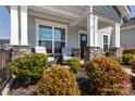Inviting front porch featuring stone columns, outdoor seating, and lush landscaping, creating a cozy entrance at 2296 Idol Rock Dr, Indian Land, SC 29707