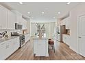 Bright, modern kitchen with white cabinets, granite countertops, stainless steel appliances, and island with seating at 2610 Greenmarket Dr, Charlotte, NC 28217
