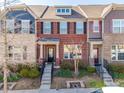 Charming brick townhome featuring neat landscaping, black shutters, and a welcoming front porch at 2635 Winter Thistle Way, Indian Land, SC 29707