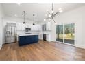 Bright kitchen open to the dining area, featuring stainless appliances, and a large island with wood flooring at 302 Lincoln St, Belmont, NC 28012