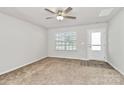 Bright living room featuring carpet, a ceiling fan, and a large window at 508 Hawley St, Charlotte, NC 28214