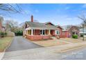 Charming brick home featuring a covered front porch and long driveway, set in a well-maintained residential area at 609 2Nd Ne St, Hickory, NC 28601
