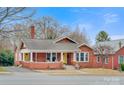 Charming red brick home boasts a covered front porch, complemented by a well-maintained lawn and classic architectural details at 609 2Nd Ne St, Hickory, NC 28601