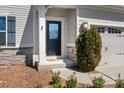 Inviting front entrance with a black door, decorative sidelight, and stone accents at 7217 Kenyon Dr, Denver, NC 28037