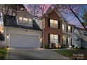 Beautiful shot of the home at twilight showcasing a two-car garage and manicured lawn at 8706 Fox Tail Ln, Huntersville, NC 28078