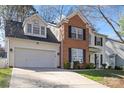 Well-maintained two-story home featuring a brick facade, two-car garage, and a neatly landscaped front yard at 8706 Fox Tail Ln, Huntersville, NC 28078