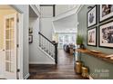 Inviting foyer with hardwood floors, staircase, and view into the living room at 8706 Fox Tail Ln, Huntersville, NC 28078