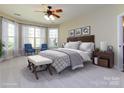 Serene primary bedroom boasts large windows, neutral tones, and a cozy sitting area for relaxation at 8830 Beaver Creek Dr, Charlotte, NC 28269