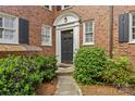 Close-up of the front door with decorative trim and manicured bushes at 108 Colville Rd # 21B, Charlotte, NC 28207