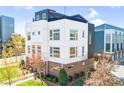 Striking modern townhome with white exterior, complemented by well-kept landscaping and trees at 111 W Poindexter Dr, Charlotte, NC 28203