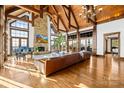 Expansive living room with vaulted ceilings, stone fireplace, grand piano, and hardwood floors at 12613 Oak Grove Rd, Stanfield, NC 28163