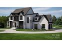 Beautiful two-story home with a manicured lawn and a circular driveway leading to a two car garage at 13820 E Rocky River Rd, Davidson, NC 28036